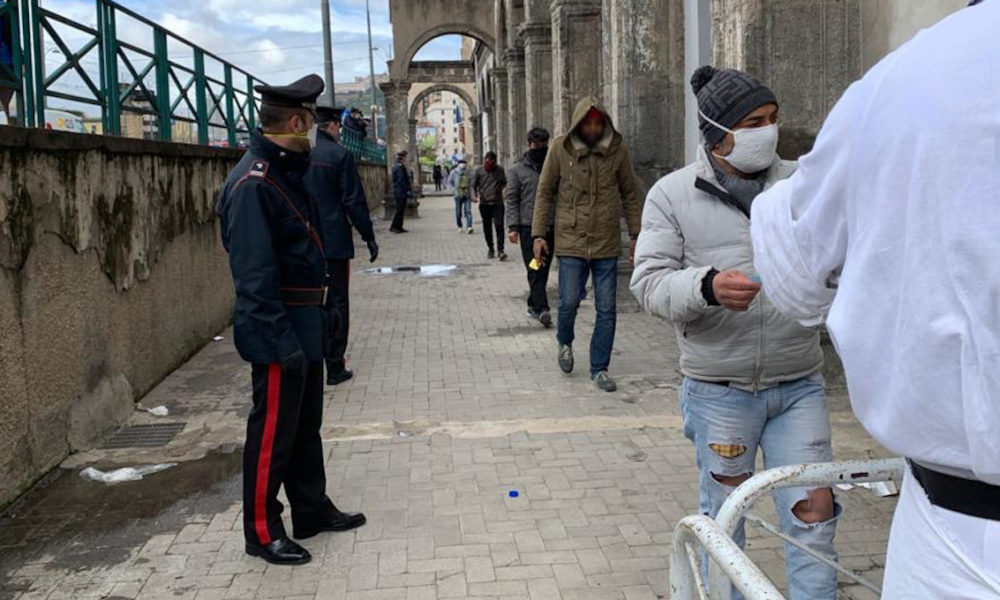 Carabinieri gestiscono ordine nella fila per la distribuzione dei pasti