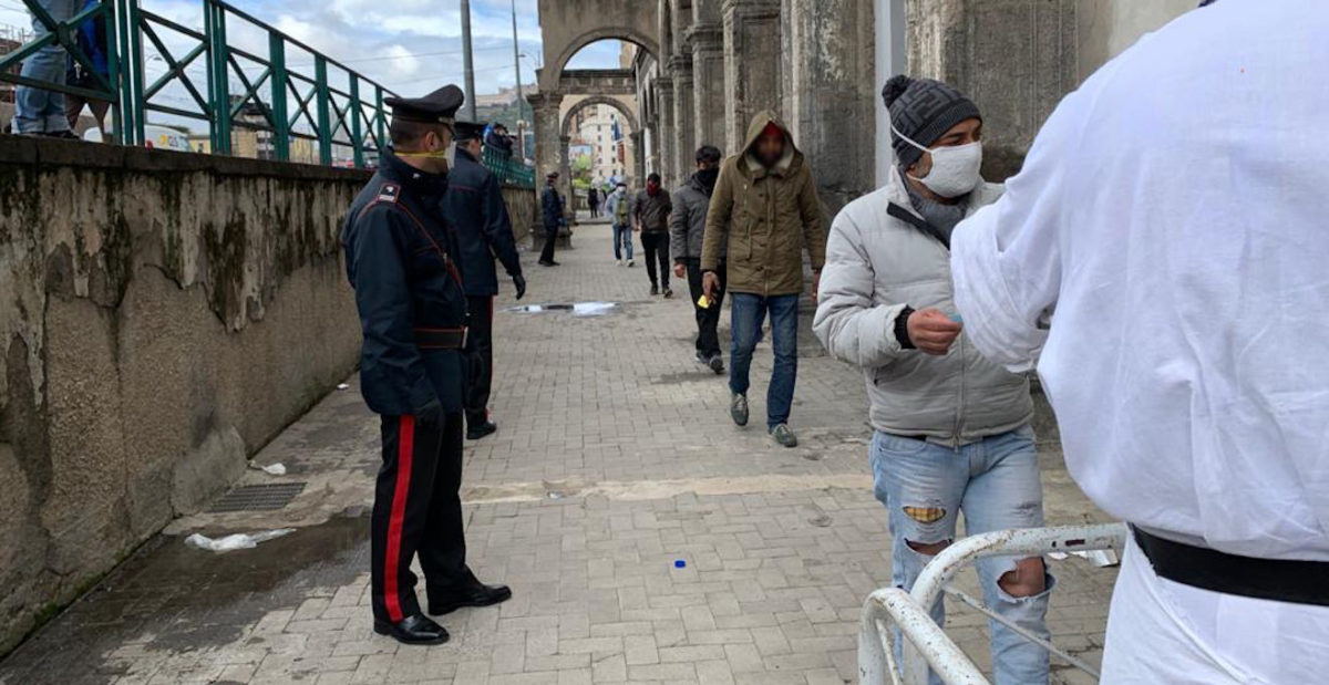 Carabinieri gestiscono ordine nella fila per la distribuzione dei pasti